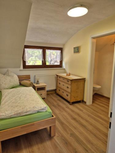 a bedroom with a bed and a desk and a sink at Dahoam am Silberberg in Bodenmais