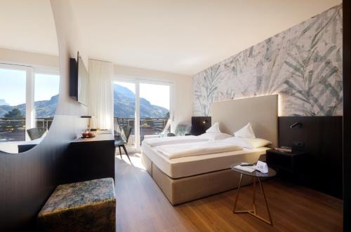 a hotel room with a bed and a balcony at Hotel Ladurner in Merano