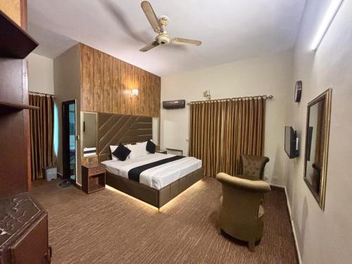a bedroom with a bed and a ceiling fan at Green Land Hotel Lahore in Lahore