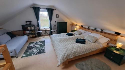 a bedroom with a large bed and a couch at Cseligevi Vendégház in Szekszárd