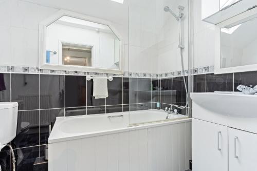 a white bathroom with a sink and a mirror at Spacious 3BR House -Sleeps 7 - Contractor Friendly in Grimsby