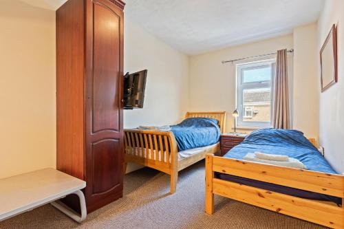 a bedroom with two beds and a window at Spacious 3BR House -Sleeps 7 - Contractor Friendly in Grimsby