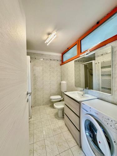 a bathroom with a washing machine and a toilet at Solleone 18 - Sea, Sun e Pool in Cavallino-Treporti