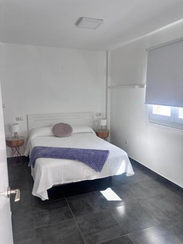 a white bedroom with a bed with a purple blanket at ViLLA DANEIRA LUX in Mogán