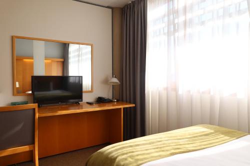 a hotel room with a television and a bed at The Jubilee Hotel in Nottingham