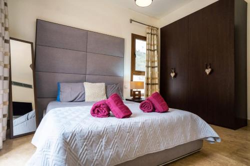 a bedroom with a large bed with pink pillows at Beau Views Seven in Peyia
