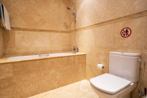 a bathroom with a toilet and a bath tub at Beau Views Seven in Peyia