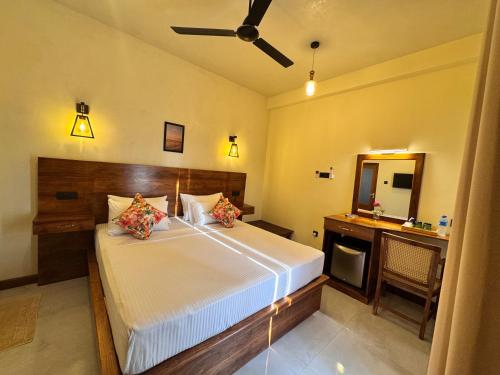 a bedroom with a bed with a ceiling fan at Novara Haven Airport Transit Hotel in Katunayaka