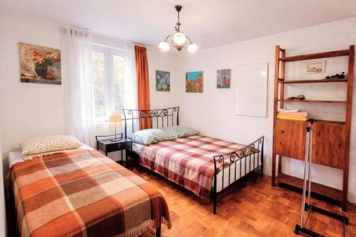 a bedroom with two beds and a crib at Art house Tufi in Bistrica ob Sotli