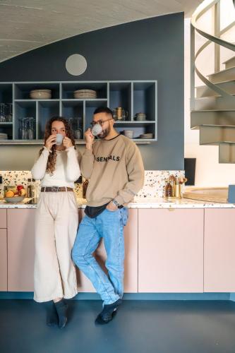 a man and a woman standing in a kitchen at Les Doms d'Alfred - AKWADOM in Ten Eiken