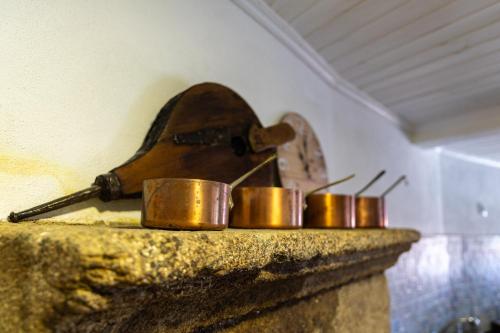 a group of copper pans sitting on a counter at Casa do Balcão in Meda