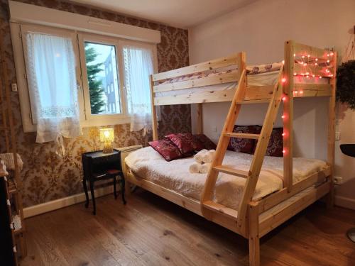 a bedroom with a wooden bunk bed with a ladder at Luxy Room in Courseulles-sur-Mer