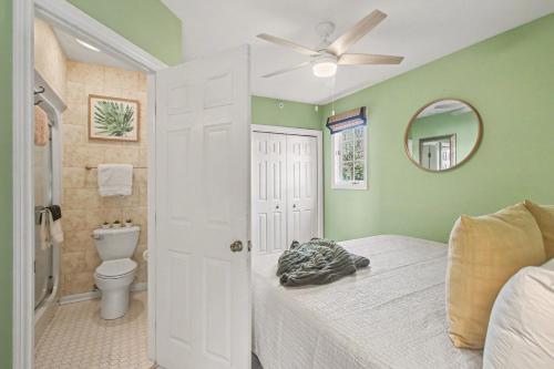 a bedroom with a bed and a toilet and a ceiling fan at Inn at the Park Bed and Breakfast in South Haven