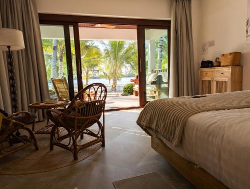 a bedroom with a bed and a table and chairs at Mint Lotus Resort - Koh Kood in Ban Bang Bao