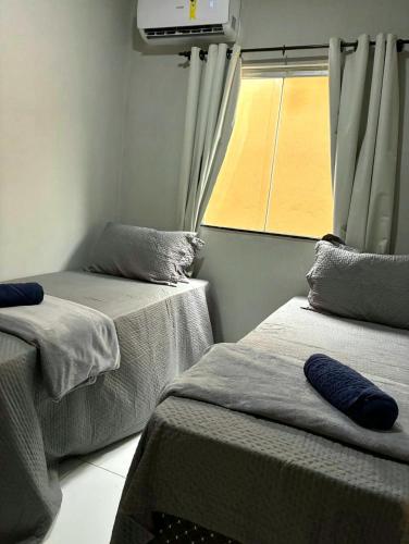 two beds in a room with a window at Dunas residence casa 03 in Santo Amaro