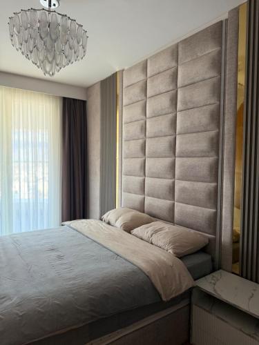 a bedroom with a large bed and a chandelier at Executive Sky Residence in Skopje