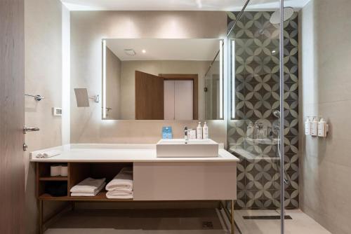a bathroom with a sink and a mirror at Radisson Resort Ruza Vjetrova in Dobra Voda