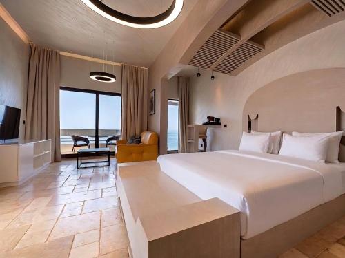 a hotel room with a large bed and a television at Radisson Resort Ruza Vjetrova in Dobra Voda