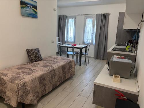 a bedroom with a bed and a table and a kitchen at Apartment Orio Volta in Orio al Serio