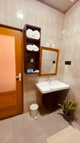 a bathroom with a sink and a mirror and a toilet at Novara Haven Airport Transit Hotel in Katunayaka