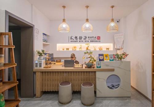a woman is sitting at a counter in a store at JINGJING·YUNXI·WEITANG HOTEL in Zhangjiajie
