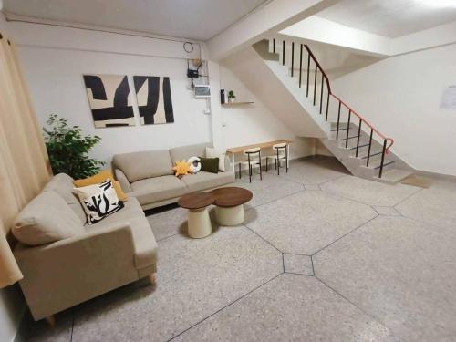 a living room with a couch and a staircase at D72 Family House, 8PAX 3BR Hat Yai Middle Town in Hat Yai