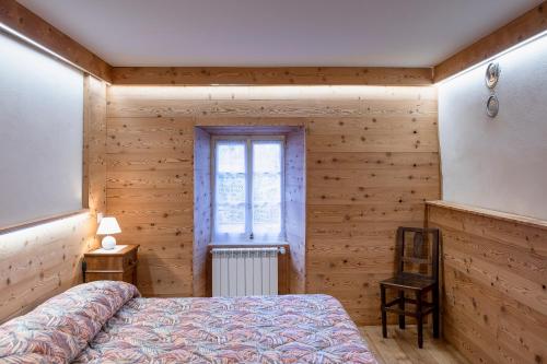 a bedroom with wooden walls and a bed and a window at oasi del relax in Scopello