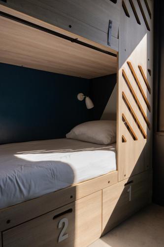 a bedroom with a bunk bed in a wooden cabinet at SLO HOSTEL Bordeaux in Bordeaux