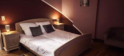 a bedroom with a bed with two nightstands and two lamps at Résidence Bayard in Dinant