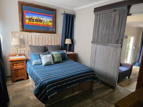 a bedroom with a bed with a blue comforter at The Pot in Pretoria