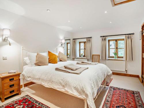 a bedroom with a large white bed and a rug at 1 Bed in Chepstow oc-91941 in Chepstow
