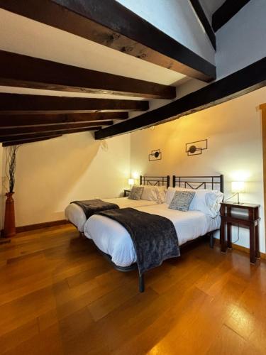 a bedroom with a large bed and a wooden floor at El Rincón de Potes in Potes