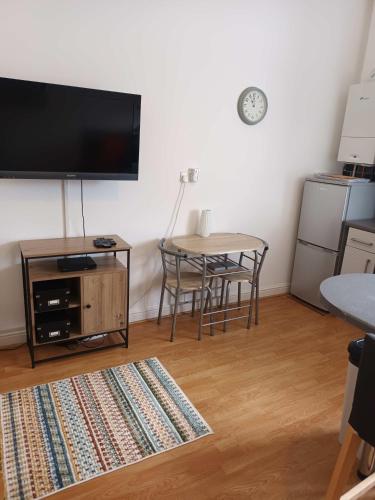 a living room with a table and a flat screen tv at Charming 1-bed Southside Flat in Great Location in Kings Park