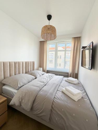a bedroom with a large bed and a window at Jaśminowy Apartament in Sławno