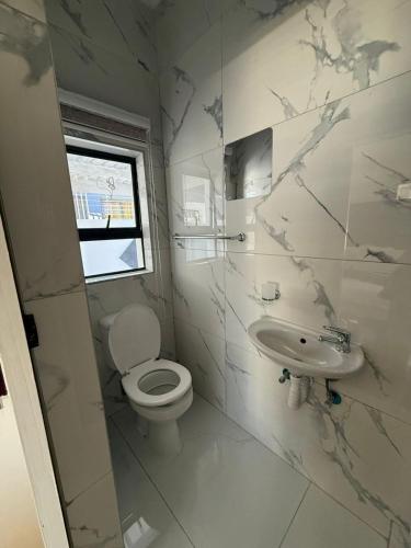 a bathroom with a toilet and a sink at Black & White Guest House in Parow