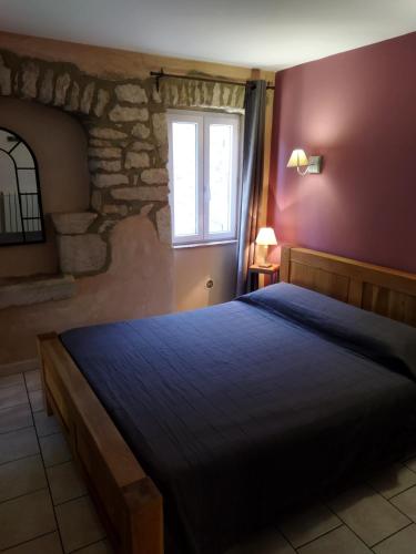 a bedroom with a large bed with a window at Chambres d'hôtes Mas Lassagne in Vagnas