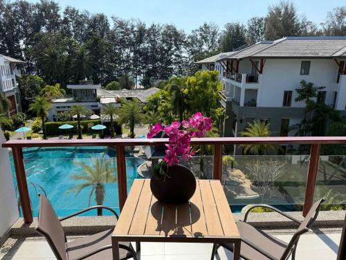 a table with a vase of flowers on a balcony at Pearl of Naithon beach 4 Bedrooms in Phuket