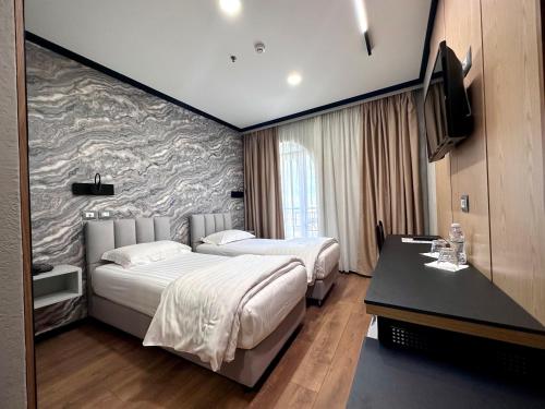 a hotel room with two beds and a television at PANORAMA Rooms Hotel near the Old Bazaar in Krujë