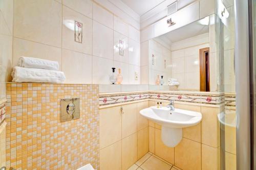 a bathroom with a sink and a mirror at Apartamenty Retro in Poznań