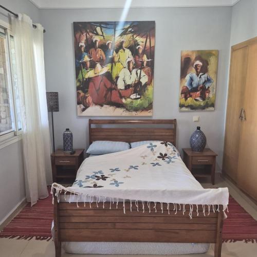 a bedroom with a bed and a painting on the wall at Résidence du golf in Fez