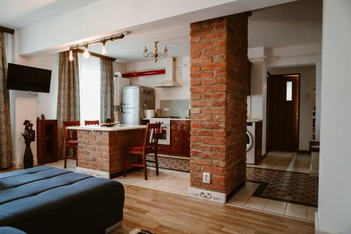 ein Wohnzimmer mit einer Ziegelsäule und eine Küche in der Unterkunft COM Home Tarnaveni - Free Parking - 24h Self check-in in Tîrnăveni