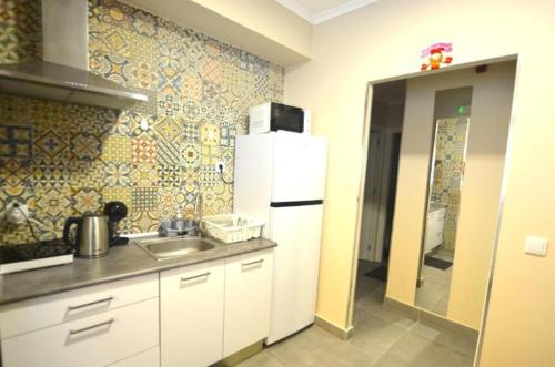 a kitchen with a sink and a white refrigerator at Stay DP Setúbal in Setúbal