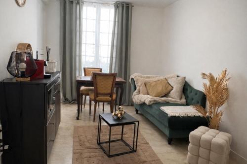 a living room with a green couch and a table at Gîte de Linéa Centre de Loches in Loches