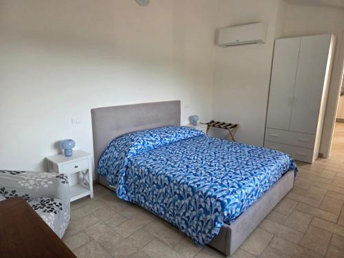 a bedroom with a bed with a blue comforter at Il Grottino di Sarzana in Sarzana
