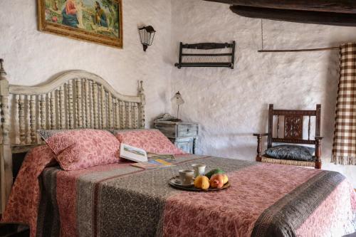a bedroom with a bed with a tray of fruit on it at Complejo El Alambique in Algatocín