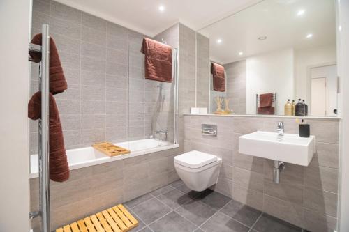 a bathroom with a toilet and a sink and a tub at The Slate Yard in Manchester