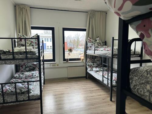 a room with four bunk beds and a window at Boberger Hostel in Hamburg