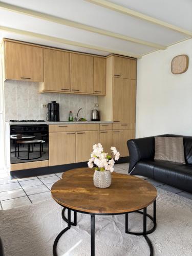 a living room with a coffee table and a kitchen at Appartementen Koets in Biggekerke