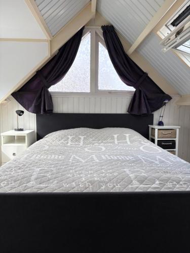 a bedroom with a white bed with a window at Appartementen Koets in Biggekerke