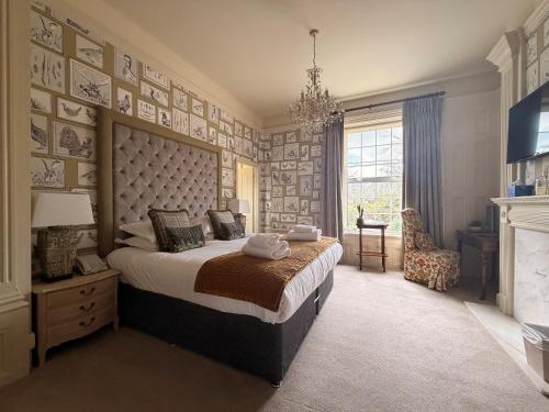 a bedroom with a large bed and a fireplace at Moorhill House Hotel in Burley